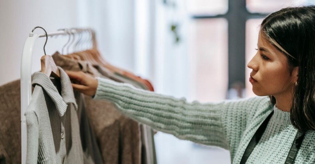 Woman browsing colorful clothing rack in fashion boutique