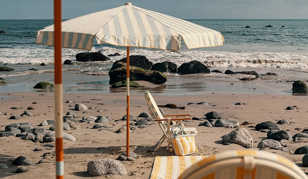 Beach scene with striped parasol and chair on rocky shoreline