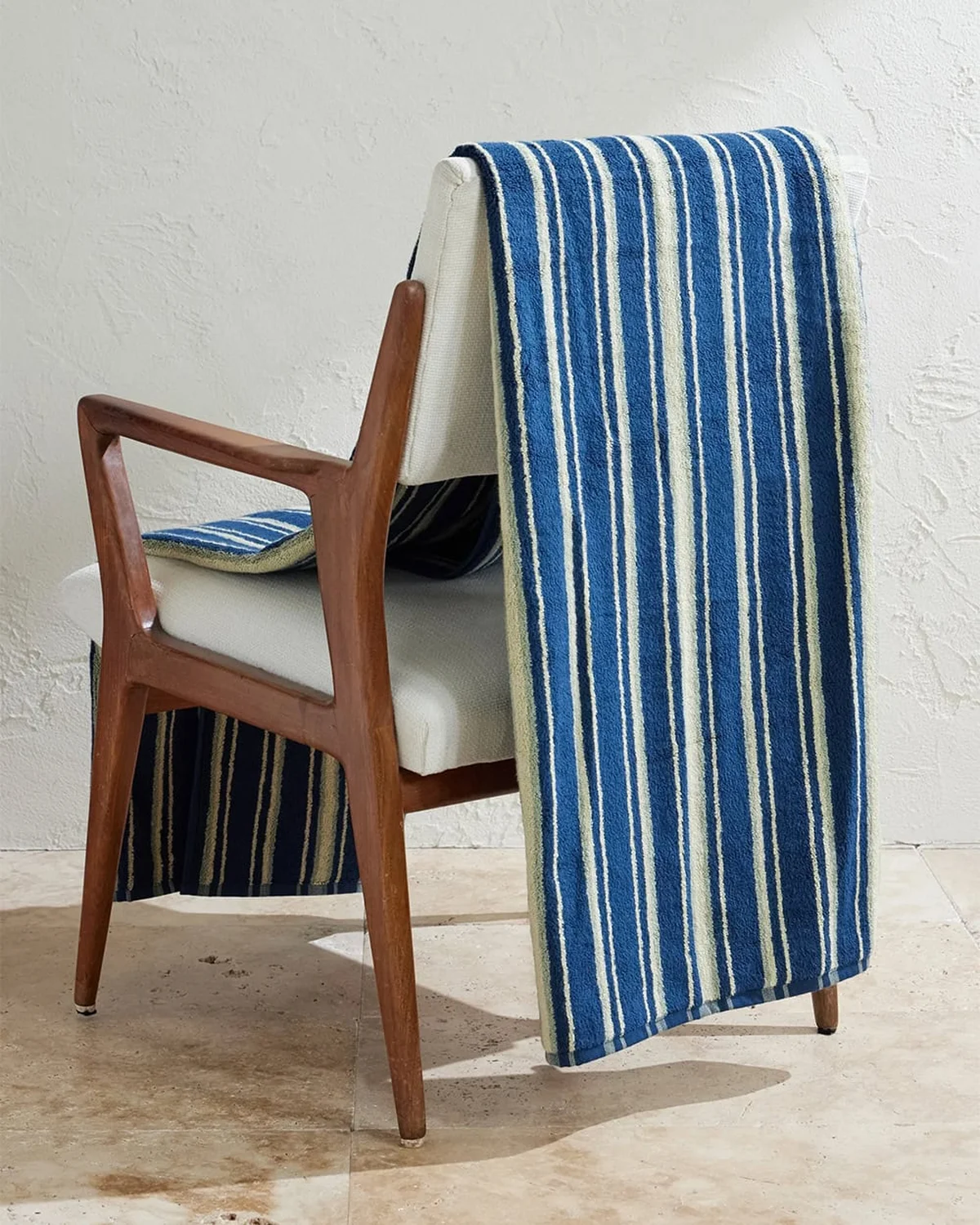 Striped beach throw draped over a wooden armchair