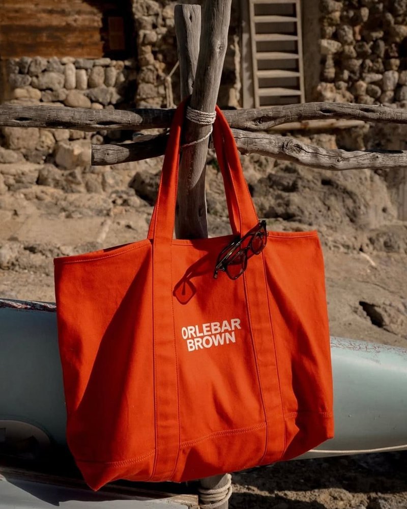 Orlebar Brown orange canvas beach tote on wooden post