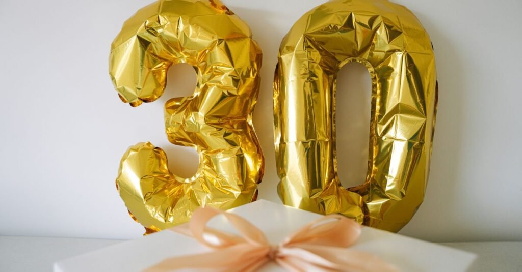 gold birthday table with wrapped gifts and warm candlelight