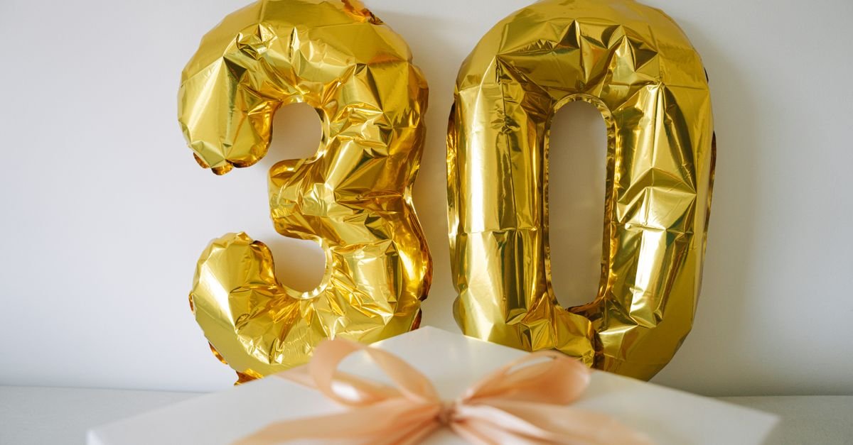 gold birthday table with wrapped gifts and warm candlelight