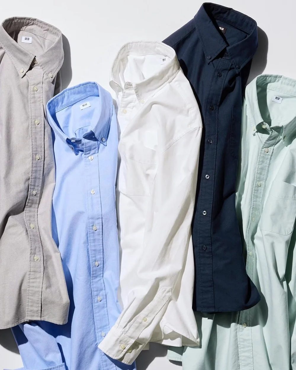 Five neutral button-down shirts in muted colors for a capsule wardrobe