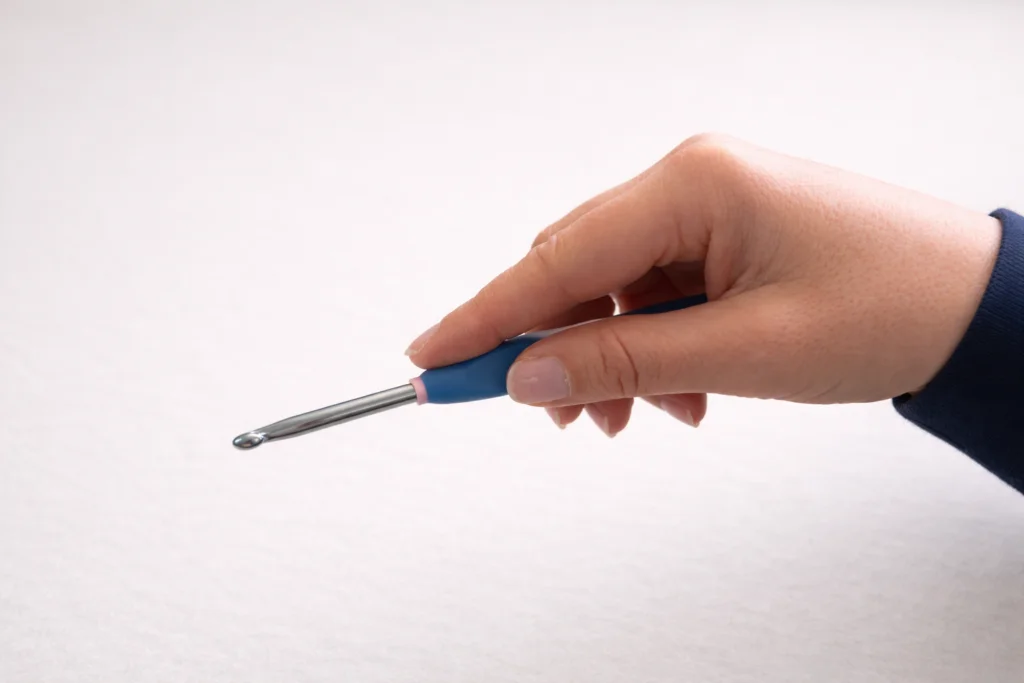 Hand demonstrating knife grip for a crochet hook