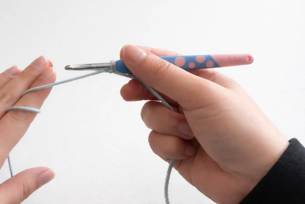Hands crocheting with a blue and pink hook
