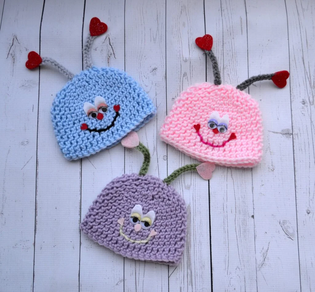 Three finished crochet love bug hats with antennae