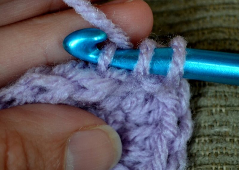 Close-up of hook inserted into back bar of stitch