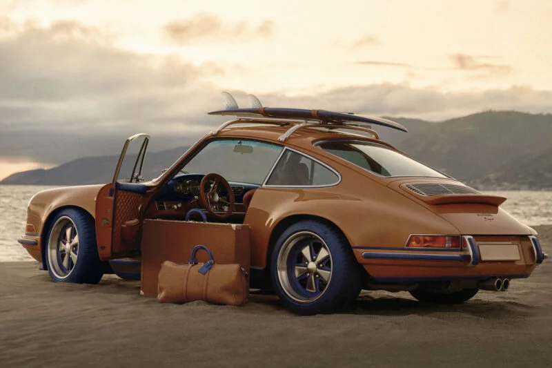 Vintage Porsche with open hood displaying Louis Vuitton luggage