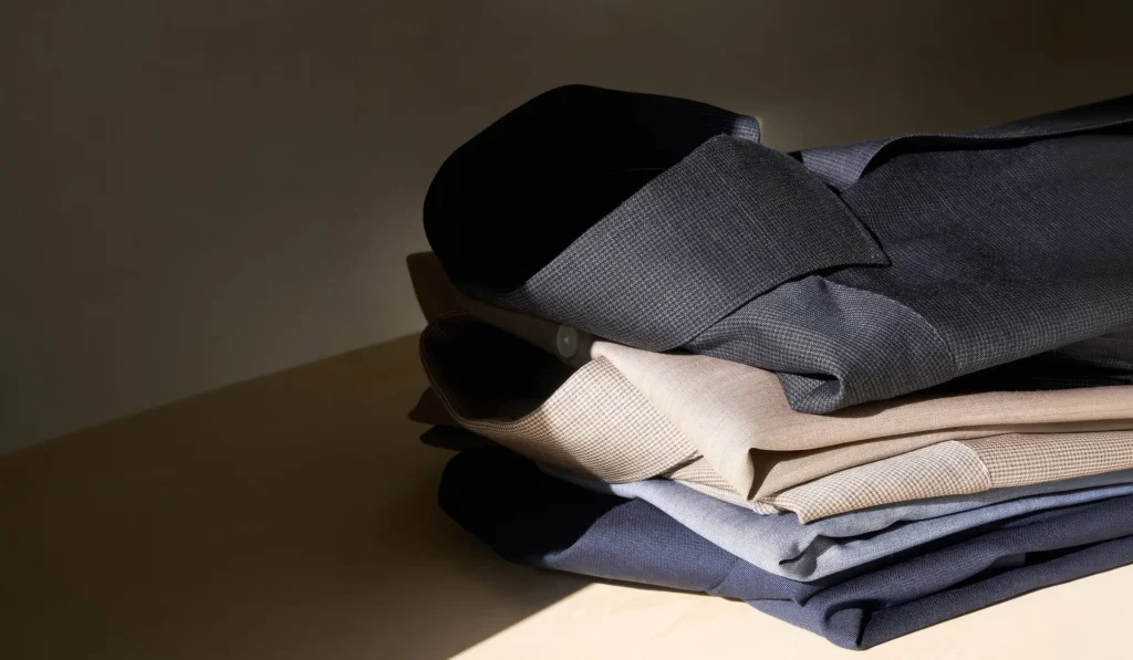 Folded luxury dress shirts in muted tones
