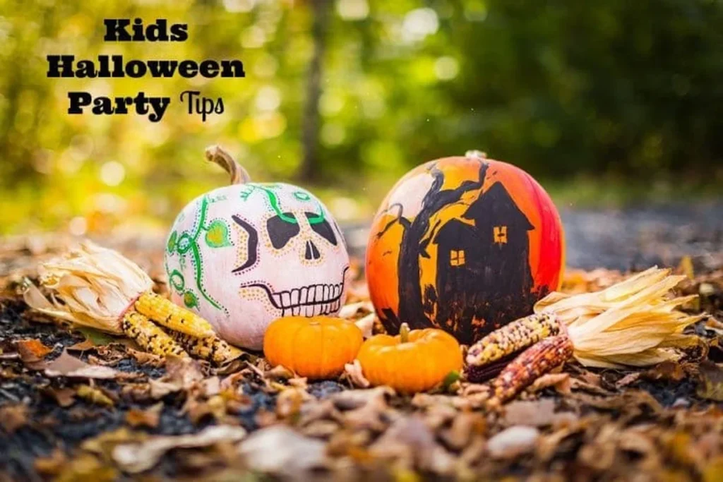 Two painted pumpkins with skull designs on autumn leaves