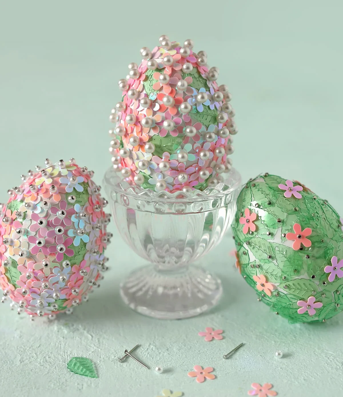 Three finished Easter eggs covered in floral sequins and pearl beads