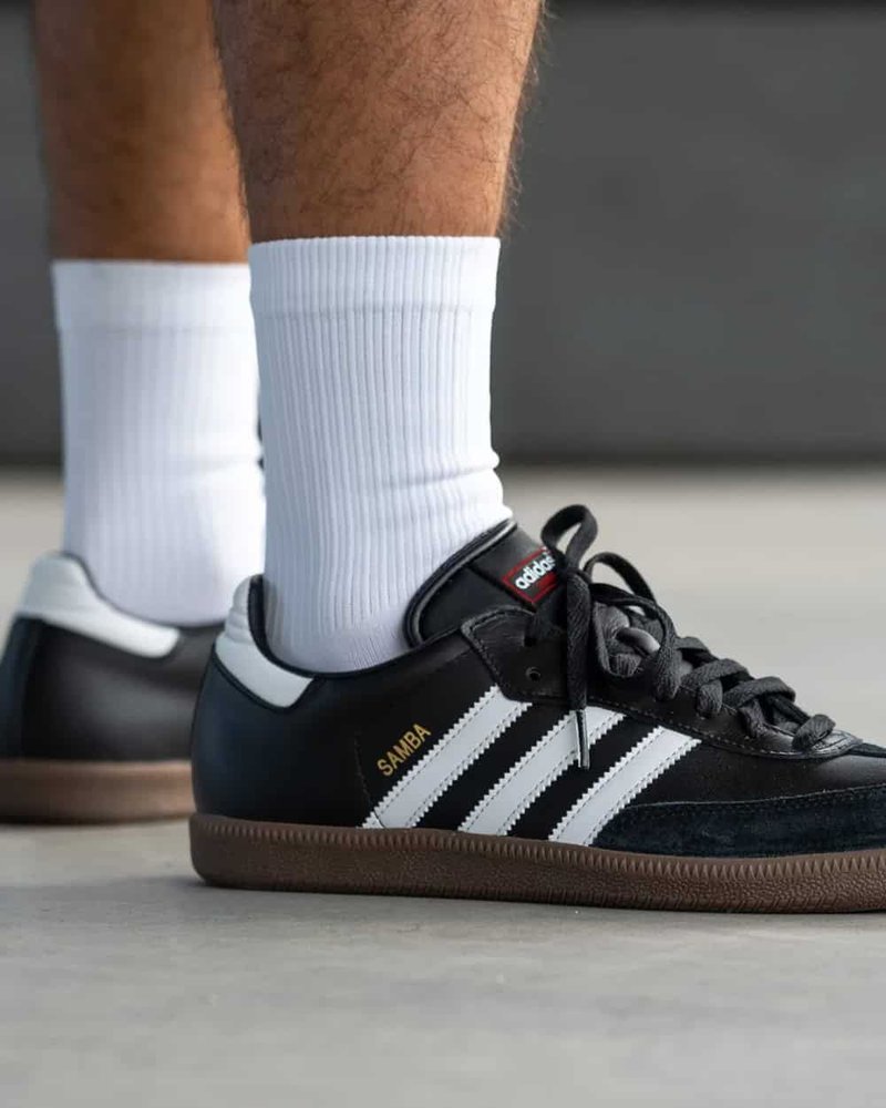 Black Adidas Samba sneakers worn with ribbed white socks