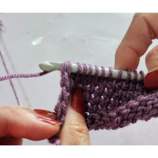 Hook working into the vertical bars of Tunisian crochet fabric